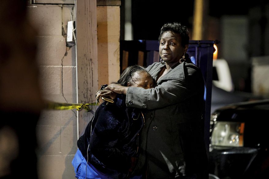 People hug and console each other at the scene of a shooting at the Gable House Bowl in Torrance, Calif., on Saturday, Jan. 5, 2019. Police responded shortly after midnight to calls of shots fired at the bowling ally. Several people were injured. (Marcus Yam/Los Angeles Times via AP)