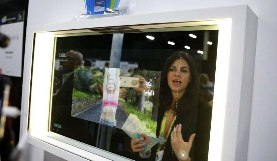 A woman demonstrates the Artemis smart mirror at the CareOS booth during CES Unveiled at CES International, Sunday, Jan. 6, 2019, in Las Vegas. The interactive mirror has video capture, virtual try-ons, facial and object recognition, and can give the user video instruction on specific makeup products, among other things. (AP Photo/John Locher) **FILE**