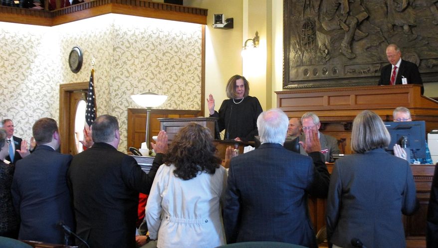 Montana Supreme Court Justice Laurie McKinnon swears in new state senators as the Montana Legislature opens its session on Monday, Jan. 7, 2019, in Helena, Mont. (AP Photo/Matt Volz)