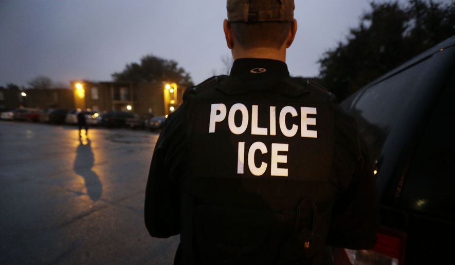 In this March 6, 2015, file photo, U.S. Immigration and Customs Enforcement agents enter an apartment complex looking for a specific undocumented immigrant convicted of a felony during an early morning operation in Dallas. (AP Photo/LM Otero, File) **FILE**