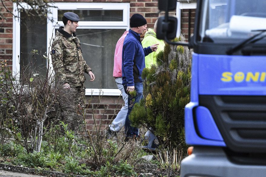 Contractors and military personnel are seen outside the home of former Russian spy Sergei Skripal in Salisbury, England, as scaffolding is delivered Tuesday, Jan. 8, 2019. The house is to be dismantled, with the roof completely removed by military teams, in the wake of the Novichok poisoning attack, as decontamination work continues. (Ben Birchall/PA via AP) ** FILE **