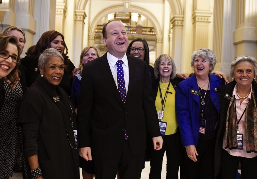Colorado Gov.-elect Jared Polis jokes with members of the statehouse and Senate before his inauguration at the Colorado State Capitol in Denver on Tuesday, Jan. 8, 2019. (AAron Ontiveroz/The Denver Post via AP)