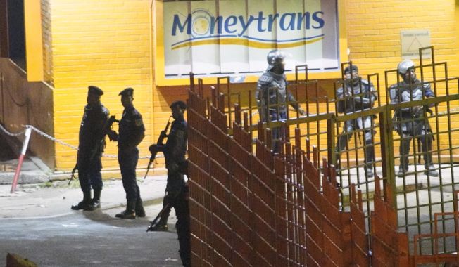 Congolese riot police take position around the electoral commission building at night in Kinshasa, Congo, Tuesday Jan. 8, 2019. As Congo anxiously awaits the outcome of the presidential election, many in the capital say they are convinced that the opposition won and that the delay in announcing results is allowing manipulation in favor of the ruling party. (AP Photo/Jerome Delay)