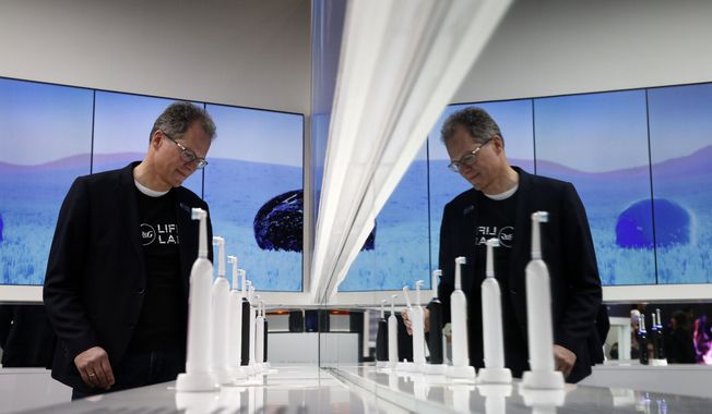 Hansjoerg Reick looks at a display of Oral-B Genius X smart toothbrushes at the Procter &amp;amp; Gamble booth before CES International, Monday, Jan. 7, 2019, in Las Vegas. (AP Photo/John Locher)