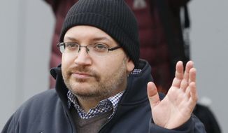 FILE - In this Jan. 20, 2016, file photo, Washington Post reporter Jason Rezaian waves at Landstuhl Regional Medical Center in Landstuhl, Germany. Rezaian says he was arrested by Iranian authorities, subjected to a sham trial and held for 18 months purely as a way to gain leverage over the American government in nuclear negotiations. Rezaian, 43, testified Tuesday, Jan. 8, 2019, in federal court as part of a multi-million dollar lawsuit against the Islamic Republic. (AP Photo/Michael Probst, File)