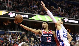 Washington Wizards forward Otto Porter Jr. (22) goes to the basket against Philadelphia 76ers guard Ben Simmons (25) and center Joel Embiid, left, during the second half of an NBA basketball game, Wednesday, Jan. 9, 2019, in Washington. The Wizards won 123-106. (AP Photo/Nick Wass) **FILE**