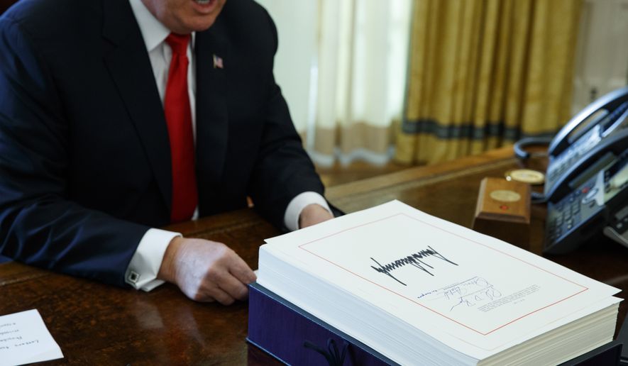 FILE- In this Dec. 22, 2017, file photo President Donald Trump speaks with reporters after signing the tax bill and continuing resolution to fund the government in the Oval Office of the White House in Washington. Millions of small business owners and their tax advisers will be in uncharted waters as they tackle 2018 returns, a new deduction that can exempt one-fifth of owners’ business income but that is complex and confusing. (AP Photo/Evan Vucci, File)