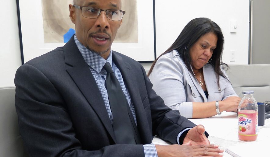 FILE - In this June 28, 2017, file photo, Patrick Pursley, left, talks at his attorney's office in Chicago. Pursley, who has been imprisoned for more than two decades for a murder conviction obtained with shoddy ballistic evidence, is getting a chance to prove his innocence with a new trial. The outcome of the trial that starts Thursday, Jan. 10, 2019, in Winnebago County could help pave a new path to challenge convictions that relied on ballistic analysis once thought to be infallible. He's been free on bail since April 2017. (AP Photo/Ivan Moreno File)