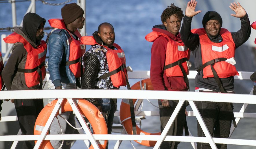 Migrants wave as they disembark at Hay Wharf, Pieta, Malta, Wednesday, Jan. 9, 2019. The 49 rescued migrants who were stranded at sea since last month were brought to Malta and then distributed among eight European Union countries. The deal, announced by Maltese Prime Minister Joseph Muscat, breaks a stalemate that began after 32 were rescued by a German aid group&#39;s vessel on Dec. 22. The other 17 were rescued on Dec. 29 by a different aid boat. Both Italy and Malta have refused to let private rescue ships bring migrants to their shores. (AP Photo/Rene Rossignaud)