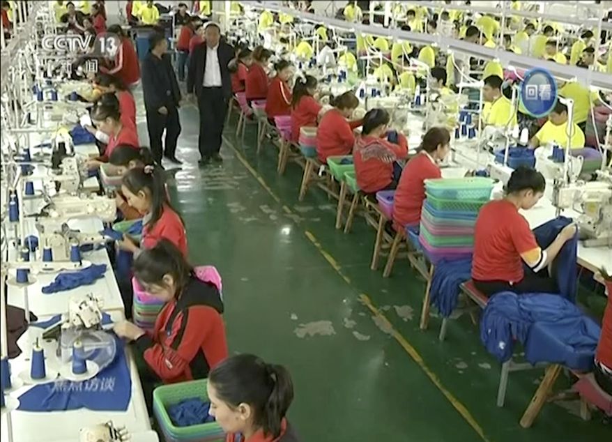 In this file image from undated video footage run by China's CCTV via AP Video, Muslim trainees work in a garment factory at the Hotan Vocational Education and Training Center in Hotan, Xinjiang, northwest China. A U.S. company that stocks college bookstores with T-shirts and other team apparel cut ties Wednesday, Jan. 9, 2019, with a Chinese company that drew workers from an internment camp holding targeted members of ethnic minority groups. (CCTV via AP Video, File)