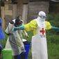 In this Sunday, Sept 9, 2018, photo, a health worker sprays disinfectant on his colleague after working at an Ebola treatment center in Beni, Eastern Congo. (AP Photo/Al-hadji Kudra Maliro) **FILE**