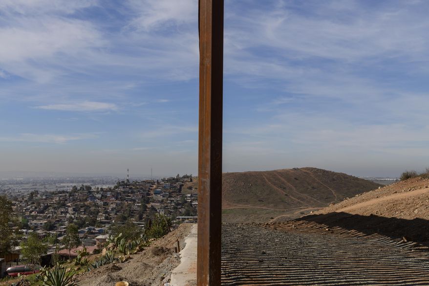 This Saturday, Dec. 22, 2018, file photo shows Tijuana, Mexico, left, and San Diego, Calif., separated by a U.S. border fence. (AP Photo/Daniel Ochoa de Olza)