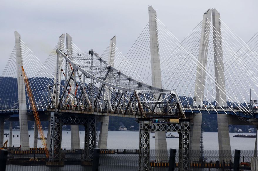 FILE - In this Sept. 7, 2018 file photo, a section of the old Tappan Zee Bridge, center, is framed by the newly-constructed Gov. Mario M. Cuomo Bridge in Nyack, N.Y. The planned demolition of the old Tappan Zee Bridge on Saturday, Jan 12, 2019 has been postponed due to inclement weather. Tappan Zee Constructors said on Thursday, Jan. 10, 2019, that heavy winds delayed the necessary prep work in order to take down the bridge's east anchor span with explosive charges. (AP Photo/Mark Lennihan, File)