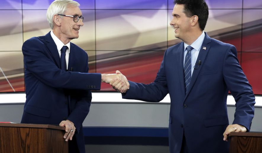FILE - In this Oct. 19, 2018, file photo, Democratic challenger Tony Evers, left, and Wisconsin Republican Gov. Scott Walker, right, shakes hands before a gubernatorial debate in Madison, Wis. A coalition of liberal-leaning groups is filing a lawsuit seeking to void several laws passed by Wisconsin Republicans that reduced the powers of the Evers, the newly elected Democratic governor. Walker signed the legislation before leaving office. (Steve Apps/Wisconsin State Journal via AP, File)