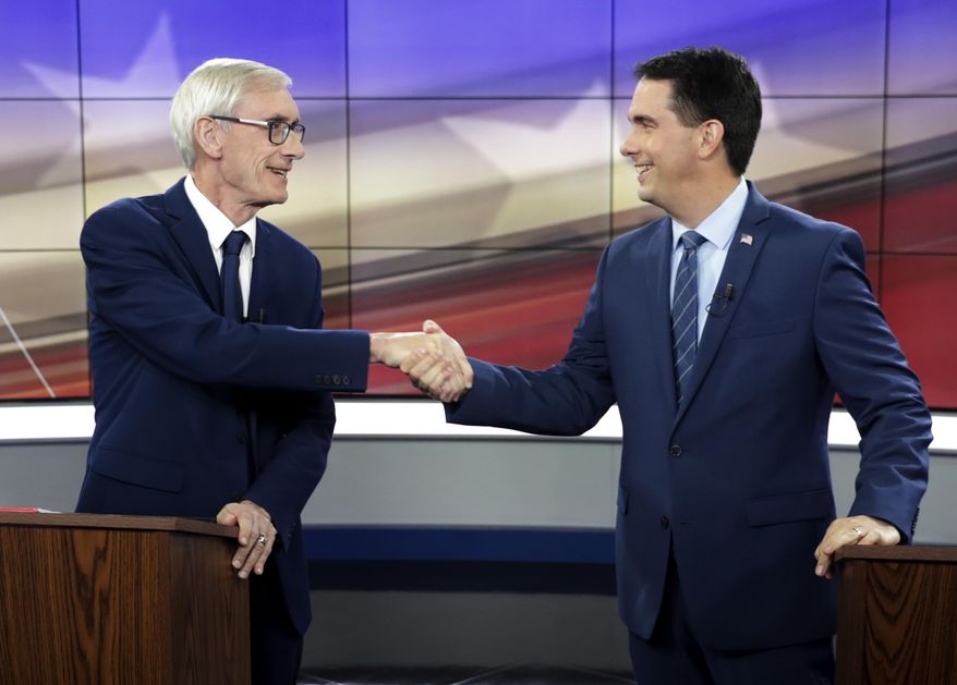 FILE - In this Oct. 19, 2018, file photo, Democratic challenger Tony Evers, left, and Wisconsin Republican Gov. Scott Walker, right, shakes hands before a gubernatorial debate in Madison, Wis. A coalition of liberal-leaning groups is filing a lawsuit seeking to void several laws passed by Wisconsin Republicans that reduced the powers of the Evers, the newly elected Democratic governor. Walker signed the legislation before leaving office. (Steve Apps/Wisconsin State Journal via AP, File)