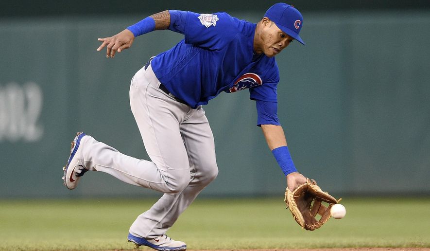 FILE - In this Sept. 8, 2018, file photo, Chicago Cubs shortstop Addison Russell fields a ground ball by Washington Nationals' Anthony Rendon during the fifth inning of the first baseball game of a doubleheader, Saturday, Sept. 8, 2018, in Washington. Russell and the Cubs have agreed to a $3.4 million, one-year contract, a relatively small $200,000 raise for a player whose relationship with the team appeared strained after a domestic violence suspension. (AP Photo/Nick Wass, File)