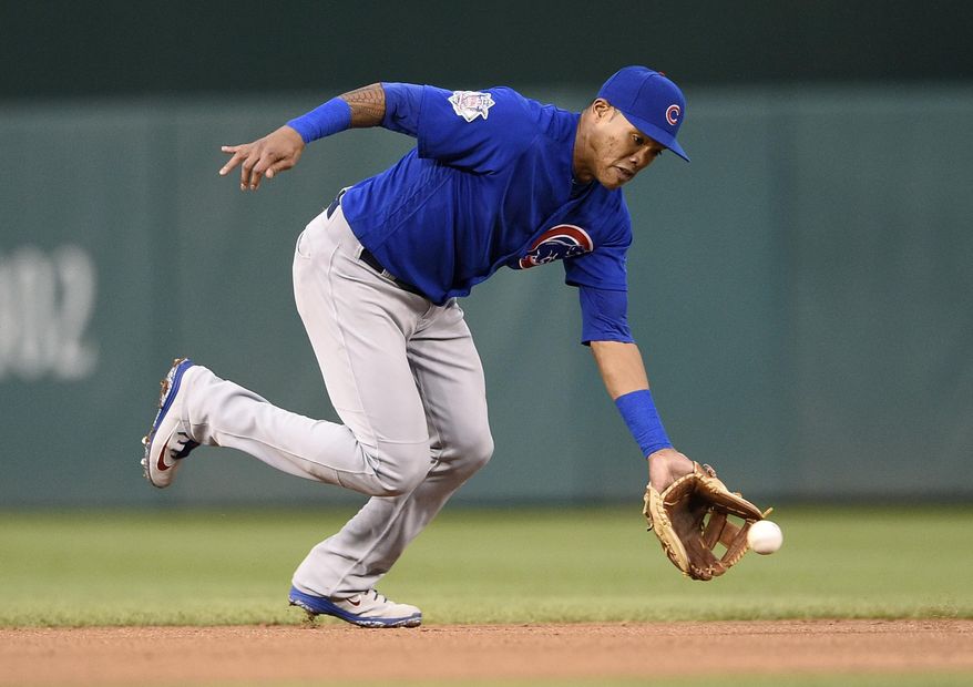 FILE - In this Sept. 8, 2018, file photo, Chicago Cubs shortstop Addison Russell fields a ground ball by Washington Nationals' Anthony Rendon during the fifth inning of the first baseball game of a doubleheader, Saturday, Sept. 8, 2018, in Washington. Russell and the Cubs have agreed to a $3.4 million, one-year contract, a relatively small $200,000 raise for a player whose relationship with the team appeared strained after a domestic violence suspension. (AP Photo/Nick Wass, File)