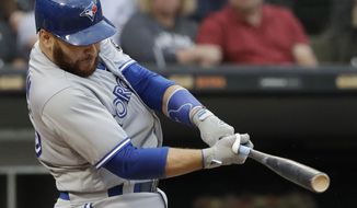 FILE - In this July 28, 2018, file photo, Toronto Blue Jays&#39; Russell Martin hits a solo home run against the Chicago White Sox during the third inning of a baseball game in Chicago. The Los Angeles Dodgers have reacquired catcher Martin in a trade with Toronto, a day after losing free agent Yasmani Grandal to Milwaukee. (AP Photo/Nam Y. Huh, File)