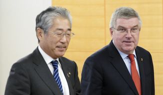 FILE - In this Nov. 30, 2018, file photo, International Olympic Committee (IOC) President Thomas Bach, right, escorts Japanese Olympic Committee (JOC) President Tsunekazu Takeda during an IOC Executive Board meeting in Tokyo. France&#39;s financial crimes office says International Olympic Committee member Takeda is being investigated for corruption related to the 2020 Tokyo Olympics. The National Financial Prosecutors office says Takeda, the president of the Japanese Olympic Committee, was placed under formal investigation for &amp;quot;active corruption&amp;quot; on Dec. 10.(AP Photo/Eugene Hoshiko, File)