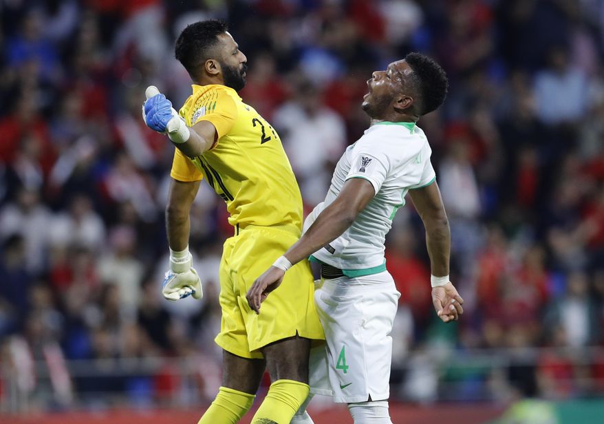 Saudi Arabia's defender Ali Albulayhi, right, celebrates with his goalkeeper Mohammed Al-Owais, left, after their teammate Fahad Al Muwallad scores the opening goal, during the AFC Asian Cup group E soccer match between Lebanon and Saudi Arabia at Al Maktoum Stadium in Dubai, United Arab Emirates, Saturday, Jan. 12, 2019. (AP Photo/Hassan Ammar)