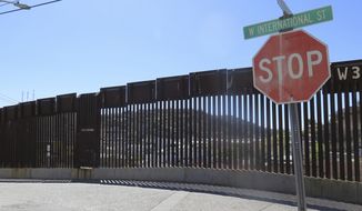 FILE - This March 9, 2016, file photo, shows a stop sign in front of the international border fence in Nogales, Ariz. Arizona Gov. Doug Ducey says building a wall isn&#39;t the only way to provide security along the U.S.-Mexico border. Ducey made border security a key issue of his 2018 campaign for re-election, and during his first term created the multi-agency Arizona Border Strike Force to focus on border area crime, especially drug smuggling. (AP Photo/Astrid Galvan, File)