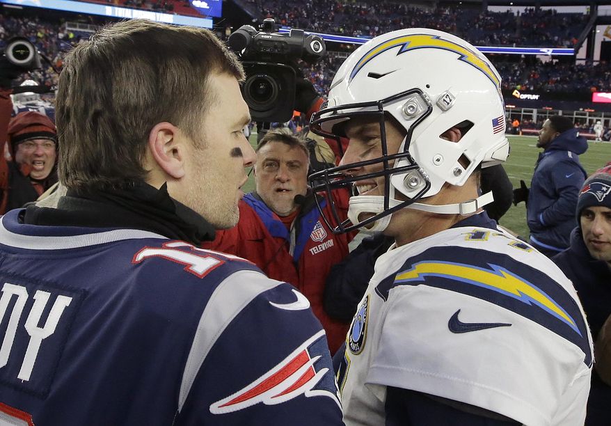 New England Patriots quarterback Tom Brady, left, and Los Angeles Chargers quarterback Philip Rivers speak at midfield after an NFL divisional playoff football game, Sunday, Jan. 13, 2019, in Foxborough, Mass. (AP Photo/Steven Senne)