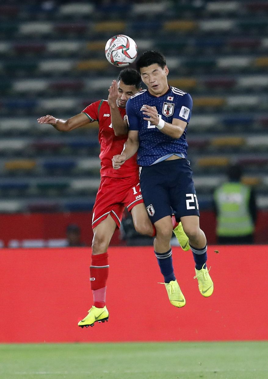 Japan's midfielder Ritsu Doan, right, goes for a header with Oman's midfielder Ahmed Al Mahaijri during the AFC Asian Cup group F soccer match between Japan and Oman at Zayed Sports City Stadium in Abu Dhabi, United Arab Emirates, Sunday, Jan. 13, 2019. (AP Photo/Hassan Ammar)