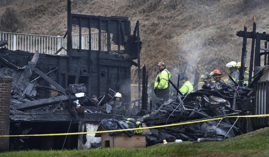Firefighters stand in the burned out structure of a home in Clay, West Virginia, Sunday, Jan. 13, 2019. The fire, which started Saturday night around 11:20pm claimed the lives of 4 foster children and is being investigated by the State Fire Marshall to determine the cause of the blaze./Charleston Gazette-Mail via AP)