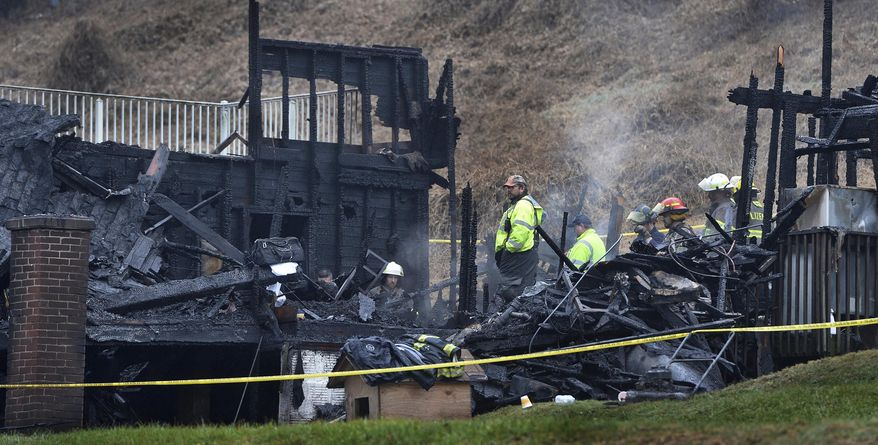 Firefighters stand in the burned out structure of a home in Clay, West Virginia, Sunday, Jan. 13, 2019. The fire, which started Saturday night around 11:20pm claimed the lives of 4 foster children and is being investigated by the State Fire Marshall to determine the cause of the blaze./Charleston Gazette-Mail via AP)