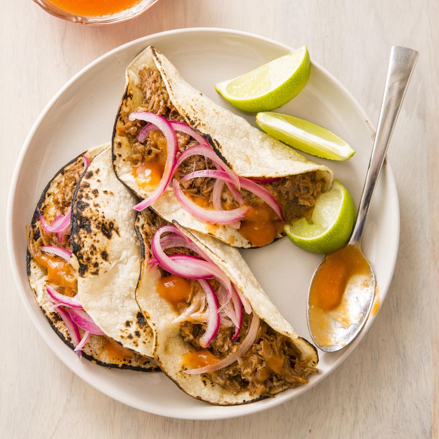This undated photo provided by America's Test Kitchen in January 2019 shows Citrus-Braised Pork Tacos in Brookline, Mass. This recipe appears in the book "Cook It In Your Dutch Oven." (Joe Keller/America's Test Kitchen via AP)