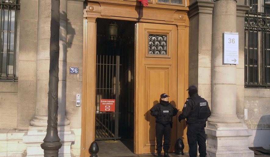 FILE - In this Friday, Feb. 6, 2015 file picture, police officers stand guard in front of the 36 Quai des Orfevres police headquarters in Paris, France. Two anti-gang French policemen are going on trial over charges of gang-raping a Canadian tourist at Paris police headquarters. (AP Photo/Francois Mori, File)