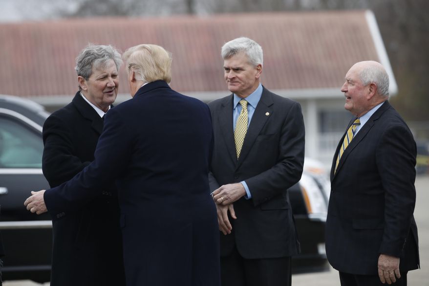 President Donald Trump is greeted by Sen. John Kennedy, R-La., left, Sen. Bill Cassidy, R-La., center, and Agriculture Sec. Sonny Purdue, right, on arrival at Louis Armstrong New Orleans International Airport, in Kenner, La., Monday Jan. 14, 2019, before traveling to New Orleans to speak at the American Farm Bureau Federation's 100th Annual Convention. (AP Photo/Jacquelyn Martin)