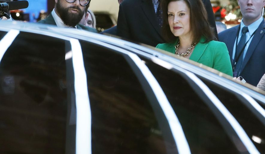 Pontus Fontaeus, left, executive design director of GAC Motors, tells Michigan Gov. Gretchen Whitmer and Lt. Gov. Garlin Gilchrist II, center, the features of the Entranze, the company's concept vehicle, Tuesday, Jan. 15, 2019, at the North American International Auto Show in Detroit. (AP Photo/Carlos Osorio)