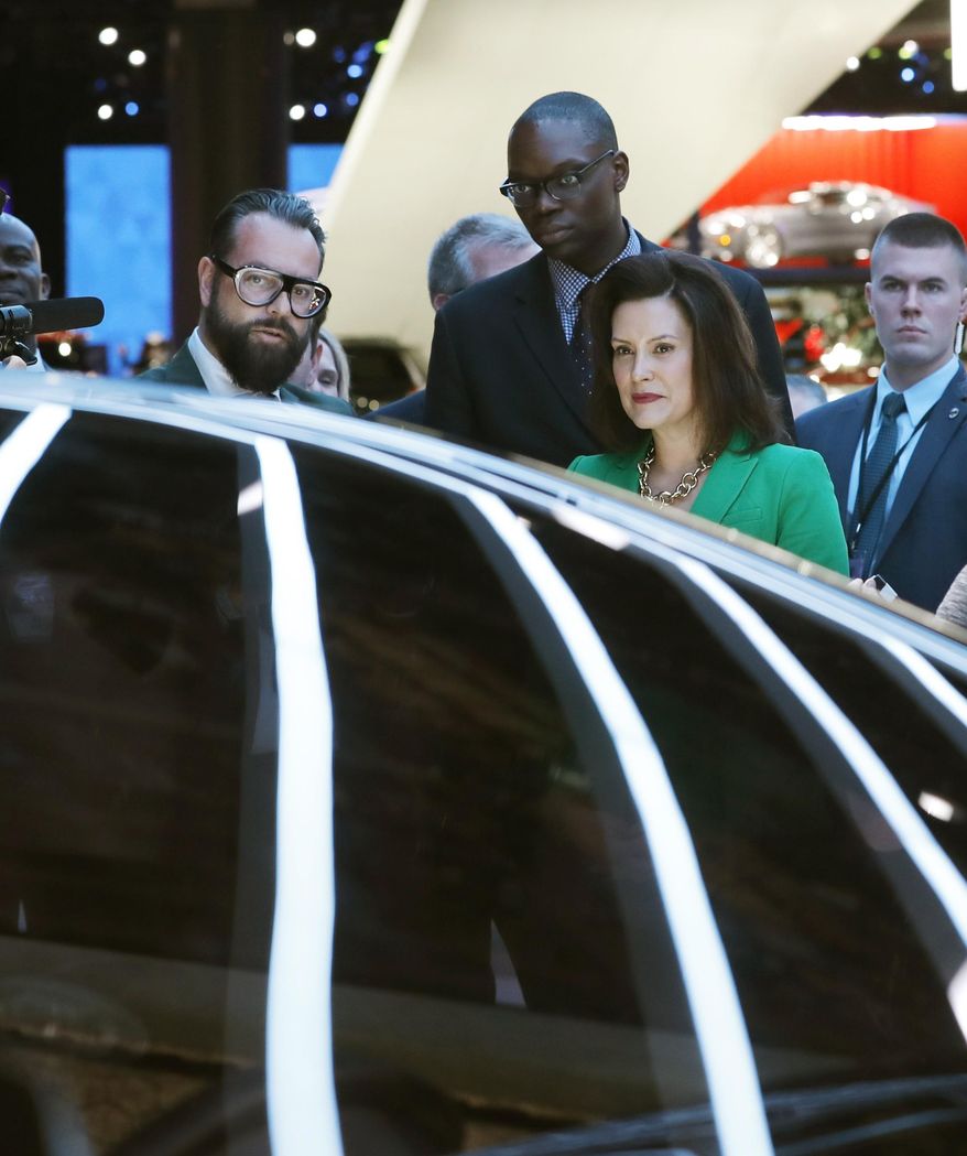 Pontus Fontaeus, left, executive design director of GAC Motors, tells Michigan Gov. Gretchen Whitmer and Lt. Gov. Garlin Gilchrist II, center, the features of the Entranze, the company's concept vehicle, Tuesday, Jan. 15, 2019, at the North American International Auto Show in Detroit. (AP Photo/Carlos Osorio)