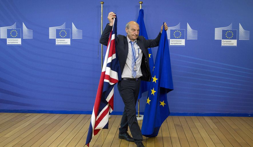 FILE - In this June 19, 2017 file photo, a member of protocol changes the EU and British flags at EU headquarters in Brussels. British lawmakers on Tuesday, Jan. 15, 2019 overwhelmingly rejected Prime Minister Theresa May&#39;s divorce deal with the European Union, plunging the Brexit process into chaos. (AP Photo/Virginia Mayo, File)