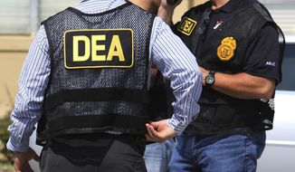 FILE - In this June 13, 2016, file photo, Drug Enforcement Administration (DEA) agents arrive on the scene of a fatal shooting in Florida. U.S. federal narcotics agent, Jose Irizarry, is accused of conspiring with a longtime DEA informant to launder more than $7 million in illicit drug proceeds from the U.S. to traffickers in Colombia, according to several current and former law enforcement officials. (Joe Burbank/Orlando Sentinel via AP, File)