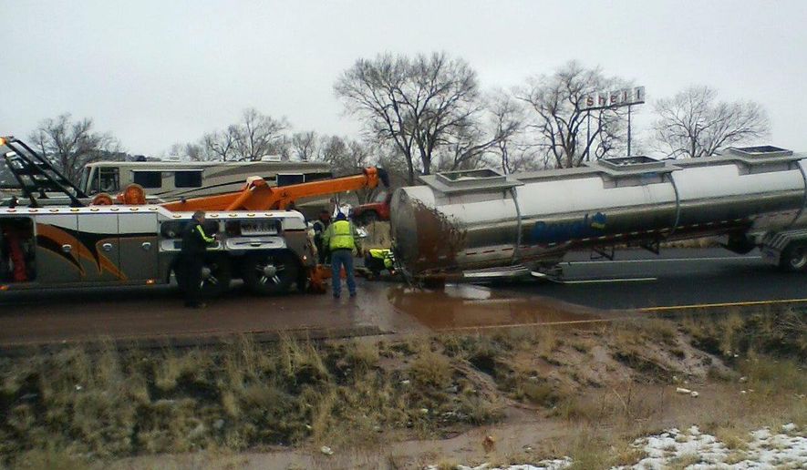 This Monday, Jan. 14, 2019 photo provided by the Arizona Department of Public Safety shows the scene of a crash about 11 miles east of Flagstaff, Ariz. A tank trucker’s trailer detached from the truck and rolled on its side on slick pavement, spilling a river of liquid chocolate onto westbound lanes of Interstate 40. Department of Public Safety spokesman Bart Graves said the wreck required cleanup crews to pour most of the 40,000 gallons (151,412 liters) of chocolate into the highway median to lighten the damaged tanker so it could be towed away. The DPS said there were no injuries and the driver was not cited. (Arizona DPS via AP)