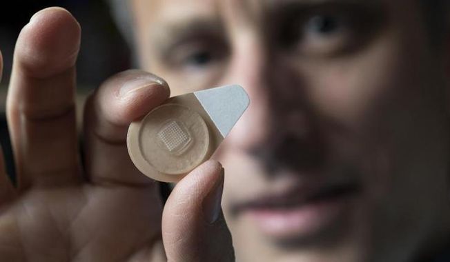 Regents Professor Mark Prausnitz holds an experimental microneedle contraceptive skin patch. Designed to be self-administered by women for long-acting contraception, the patch could provide a new family planning option. (Christopher Moore/Georgia Tech)