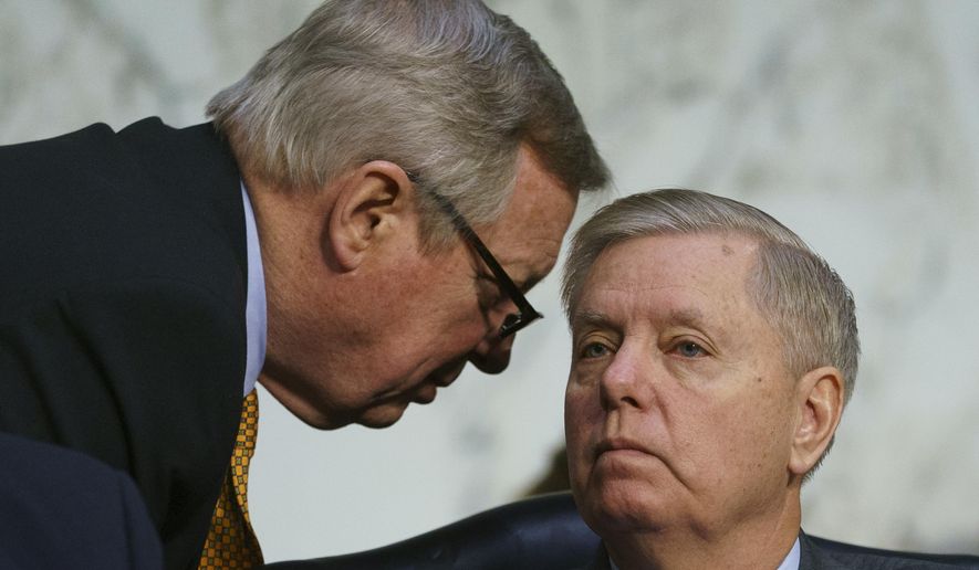 Senate Judiciary Committee Chairman Lindsey Graham, R-S.C., left, speaks committee member Sen. Dick Durbin, D-Ill., as Attorney General nominee William Barr testifies before the Senate Judiciary Committee on Capitol Hill in Washington, Tuesday, Jan. 15, 2019. (AP Photo/Carolyn Kaster)