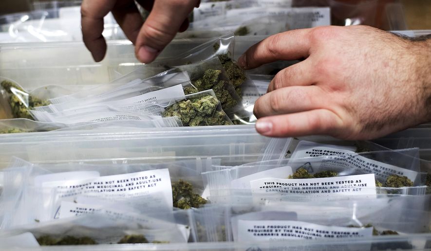 FILE - In this Jan. 6, 2018, file photo, an employee stocks cannabis at a store shortly before its first day of recreational marijuana sales in San Francisco. California has endorsed a rule that will allow home marijuana deliveries statewide, even into communities that have banned commercial pot sales. The rule finalized Wednesday, Jan. 16, 2019, by state officials was opposed by police chiefs and other critics who say it will create an unruly market of largely hidden pot transactions and encourage potential criminal activity. (AP Photo/Noah Berger, File)