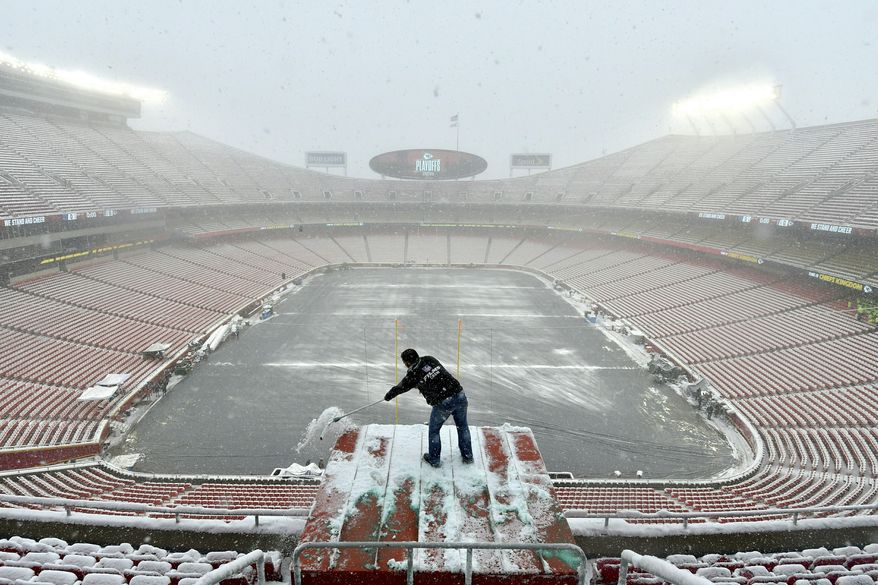 FILE - In this Jan. 12, 2019, file photo, Kyle Haraugh, of NFL Films, clears snow from a camera location at Arrowhead Stadium before an NFL divisional football playoff game between the Kansas City Chiefs and the Indianapolis Colts, in Kansas City, Mo. The Chiefs began to lay new sod inside Arrowhead Stadium on Wednesday, Jan. 16, after much of the field was torn up in the divisional round. Heavy snow that began last Friday and stopped just before kickoff left parts of the field mushy, particularly between the hash marks and along the sidelines. Those areas and the south end zone were getting fresh sod. (AP Photo/Ed Zurga, File)