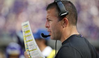 FILE - In this Sept. 23, 2018, file photo, Minnesota Vikings offensive coordinator John DeFilippo looks at his play sheet during the second half of an NFL football game against the Buffalo Bills, in Minneapolis. The Jacksonville Jaguars have hired former Minnesota offensive coordinator John DeFilippo to the same position. The Jaguars also filled five other staff positions. DeFilippo replaces Nathaniel Hackett, who was fired in late November and landed in Green Bay. (AP Photo/Bruce Kluckhohn, File)