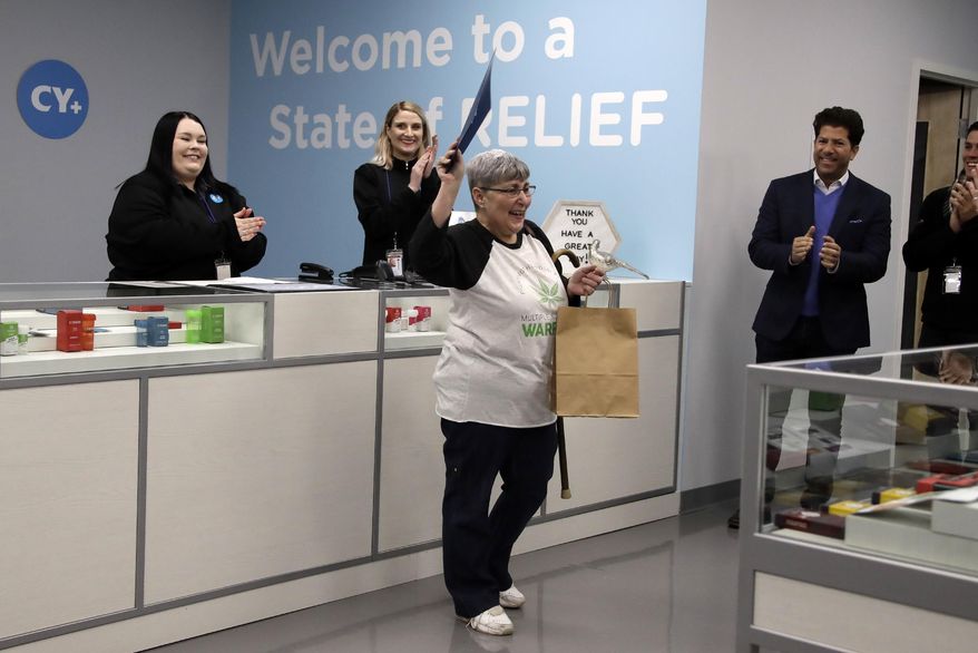 Joan Caleodis, of Martin's Ferry, Ohio, center, celebrates being one of the first patient sales of Ohio's Medical Marijuana program at Cresco Labs CY+ dispensary in Winterville, Ohio, Wednesday, Jan. 16, 2019. (AP Photo/Gene J. Puskar)