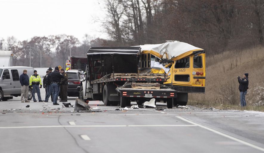 FILE - In this Dec. 5, 2019, file photo, Indiana State Police investigate a collision between an East Pulaski school bus and truck in Argos, Ind. Indiana State Police say the driver of a truck that rear-ended the school bus in December, killing one student, was removing a jacket and a sweatshirt just before the collision, according to a crash report released Wednesday, Jan. 16, 2019. (Santiago Flores/South Bend Tribune via AP, File)
