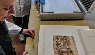 In this photo provided by the Opera Laboratori on Thursday, Jan. 17, 2019, a drawing by Leonardo Da Vinci is observed after being removed from a briefcase which carried it from the Uffizi Gallery to the Opificio delle Pietre Dure where it will undergo scientific analysis, in Florence, Italy. First-ever scientific study of a Leonardo drawing done in his youth shows the artist added details to earlier sketch. The Uffizi Galleries said that 1473 “Landscape Drawing for Santa Maria della Neve” was taken on Thursday to a Florence restoration for scientific analyses. (Opera Laboratori via AP)