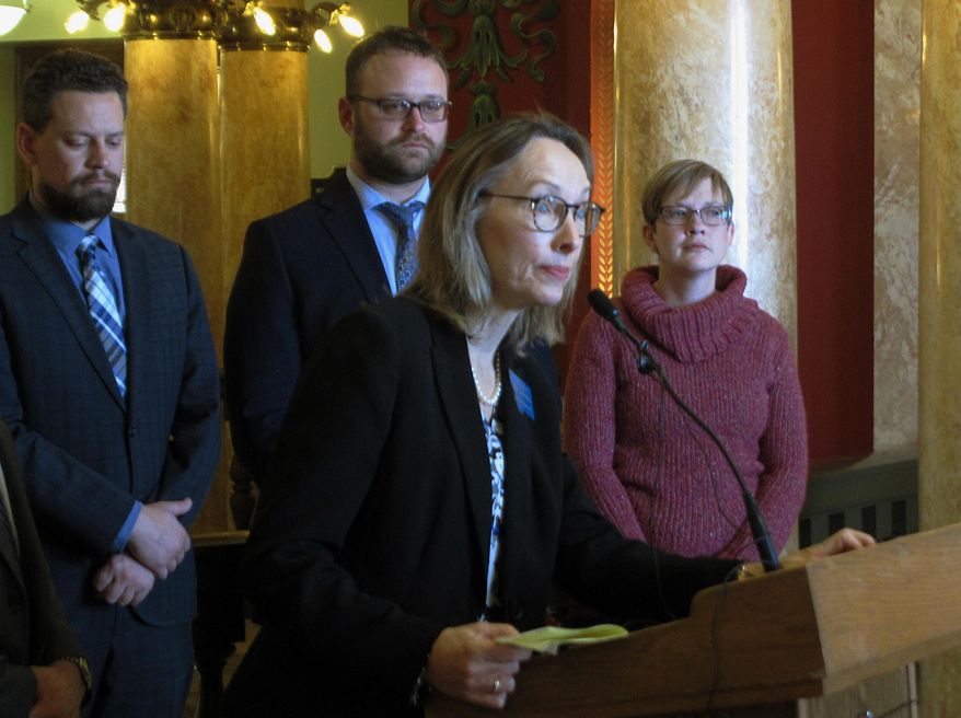 Kristen Newby, right, listens as state Rep. Mary Ann Dunwell takes a question during a news conference on Wednesday, Jan. 16, 2019, in Helena, Mont. Newby, who says she is the daughter of a former Montana high school athletic trainer accused of abusing teenage boys, says she supports a bill that would lift the statute of limitations for sex offenses against children. (AP Photo/Matt Volz)