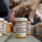 Family and friends who have lost loved ones to OxyContin and opioid overdoses leave pill bottles in protest outside the headquarters of Purdue Pharma, which is owned by the Sackler family, in Stamford, Conn. (AP Photo/Jessica Hill) ** FILE **