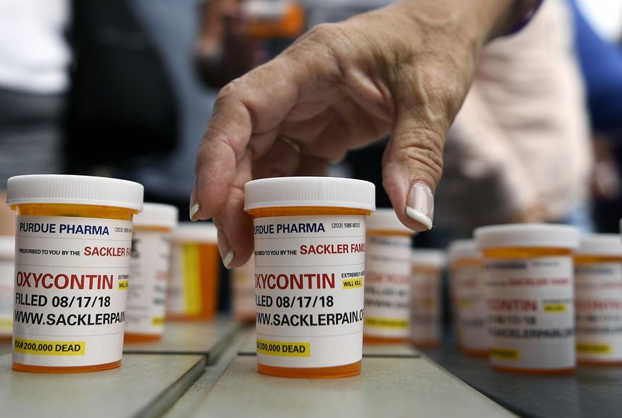 Family and friends who have lost loved ones to OxyContin and opioid overdoses leave pill bottles in protest outside the headquarters of Purdue Pharma, which is owned by the Sackler family, in Stamford, Conn. (AP Photo/Jessica Hill) ** FILE **