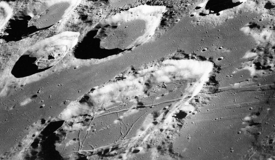 This Dec. 29, 1968, file photo made available by NASA shows the large moon crater Goclenius, foreground, approximately 40 statute miles in diameter, and three clustered craters Magelhaens, Magelhaens A, and Colombo A, during the Apollo 8 mission. For the past 290 million years, giant rocks from space have been crashing into Earth more than twice as often as they did in the previous 700 million years, according to a new study published in the Thursday, Jan. 17, 2019, edition of the journal Science. (NASA via AP, File)