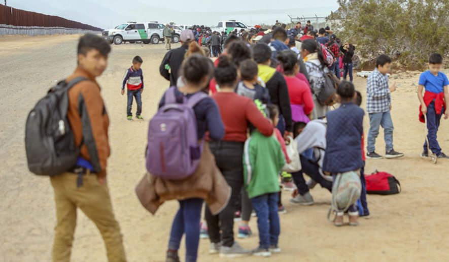 This Monday, Jan. 14, 2019 photo released by U.S. Customs and Border Protection shows some of 376 Central Americans the Border Patrol says it arrested in southwest Arizona, the vast majority of them families, who used short holes dug under a barrier to cross the border in multiple spots about 10 miles east of San Luis, Ariz. The unusually large group was almost entirely from Guatemala. (U.S. Customs and Border Protection via AP)